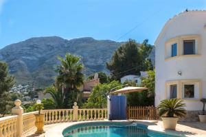 een huis en een zwembad met bergen op de achtergrond bij Casa Mar y Montaña in Denia