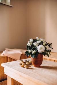 a vase with flowers on a table with some nuts at Kevade Guesthouse with Sauna in Kuressaare