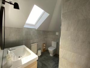 a bathroom with a sink and a toilet with a skylight at Housingcoruña playa miño 5 in Miño +15 photos