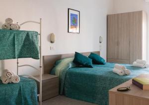 a bedroom with two beds with green sheets at Hotel Ritter in Cattolica