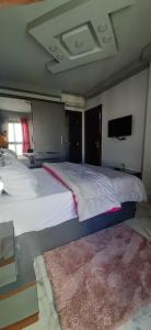 a bedroom with a large white bed with a rug at Porto Said in Port Said