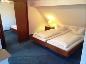 een kleine slaapkamer met een bed en een spiegel bij Pension Sanssouci in Potsdam