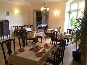 ポツダムにあるPension Sanssouciのテーブルと椅子が備わるレストラン