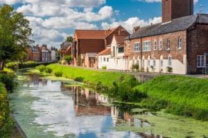 a river in a town with houses and buildings at EasyRest Spalding - 4 Beds & Free Parking - Central & Modern Open Plan Apartment - Convenient Location in Spalding