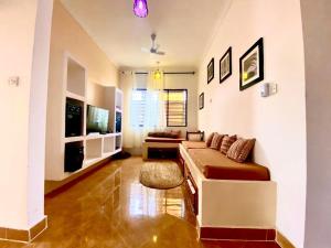 a living room with a couch and a tv at VICK Boutique Hotel with New power backup in Banda Kuu