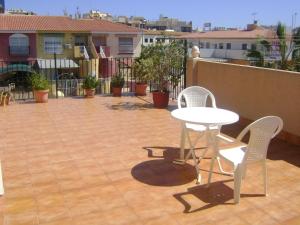 eine Terrasse mit einem Tisch und 2 Stühlen auf einem Balkon in der Unterkunft Pensión Egea II in Puerto de Mazarrón