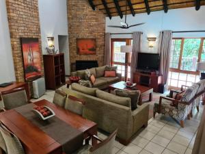 a living room with a couch and a table at Kruger Park Lodge Unit No 615 with Private Pool in Hazyview