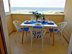 uma sala de jantar com uma mesa e cadeiras e uma janela em Bilocale Punta Rosa - Fronte Spiaggia em Otranto