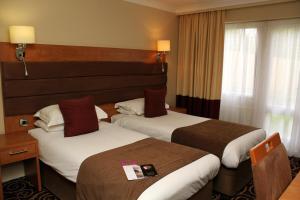 
a hotel room with two beds and two lamps at The Legacy Rose & Crown Hotel in Salisbury
