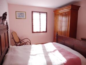 ein Schlafzimmer mit einem Bett, einem Fenster und einem Stuhl in der Unterkunft La guesnonniere in Quibou