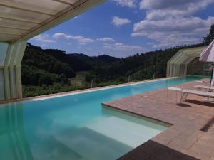 une piscine avec vue sur les montagnes dans l'établissement Bosco Della Spina, à Murlo