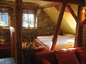 a room with a bed and a couch and windows at Lehmlounge in Monschau