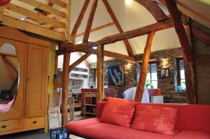ein Wohnzimmer mit einem roten Sofa und einer Steinmauer in der Unterkunft Lehmlounge in Monschau