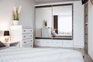 a bedroom with a large mirror and a bed at Luxury Apartments in City Center, Šiauliai in Šiauliai