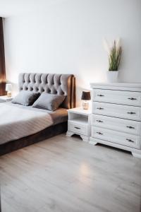 a bedroom with a bed and a white dresser at Luxury Apartments in City Center, Šiauliai in Šiauliai