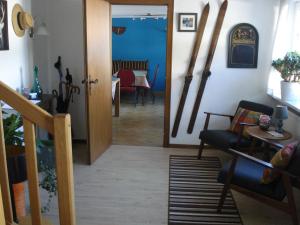 ein Wohnzimmer mit Skiern an der Wand und einer Tür in der Unterkunft B&B All Seasons in Winterberg