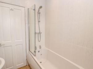 a white bathroom with a tub and a shower at Cheviot Way Cottage in Wooler +18 photos