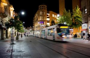 a train traveling down a city street at night at Brown Machne Yehuda, a member of Brown Hotels in Jerusalem