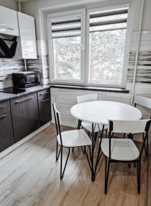 a kitchen with a table and chairs in a room at Luxury Apartments in City Center, Šiauliai in Šiauliai