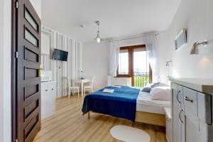 biała sypialnia z łóżkiem i stołem w obiekcie Pensjonat Riwiera z widokiem na Zalew Wiślany w mieście Krynica Morska