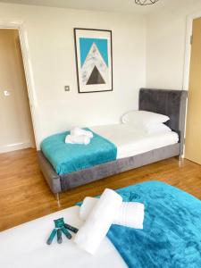 two beds in a room with towels on the floor at Tudors eSuites Spacious City Centre Apartment in Birmingham