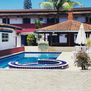 a swimming pool in front of a house at Villa Di Verona Charm Hotel in Guarujá