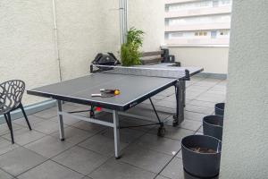a ping pong table sitting on top of a patio at Soulfactory Apartments in Neu Ulm