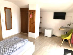 Dormitorio con cama, escritorio y TV en Gästehaus Brigitte, en Garmisch-Partenkirchen