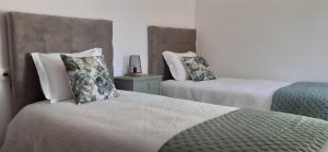 a bedroom with two beds with pillows at Pitões NatureHouse in Pitões das Júnias +66 photos