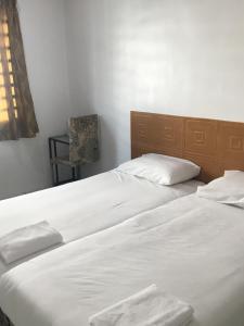 two beds sitting next to each other in a bedroom at Motel Fasa2B in Seri Manjung