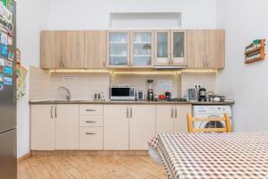 a kitchen with white cabinets and a sink and a table at Pushkin 10 Hostel in Tbilisi City