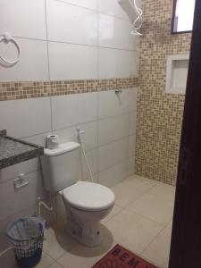 ein Badezimmer mit einem weißen WC und einem Spiegel in der Unterkunft Casa do Francês Temporada in Maceió