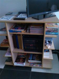 una mensola piena di libri e di televisione di Apartment Dimitrieski a Višegrad