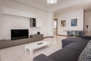 sala de estar con sofá y TV en Flats4Rent Lucia, en Verona
