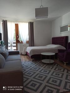 Habitación de hotel con cama y sofá en Vlašićka idila apartman Eko Fis 507 en Vlasic