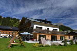 ein großes Gebäude mit einer Leiter davor in der Unterkunft Das Tannberg in Lech am Arlberg