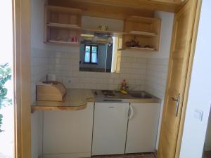 a small kitchen with white cabinets and a sink at Takács tanya Nemesvámos in Nemesvámos