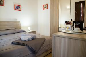 um quarto com uma cama e toalhas num balcão em Cavallotti em Sassari