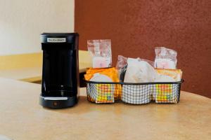 a coffee maker sitting next to a basket of food at Red Roof Inn San Antonio Airport in San Antonio