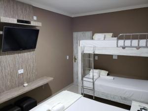 a room with two bunk beds and a flat screen tv at Hotel Recanto das Perdizes in São Paulo +85 photos