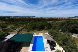 an overhead view of a swimming pool with an umbrella at Apartments Marjanovic in Vodice