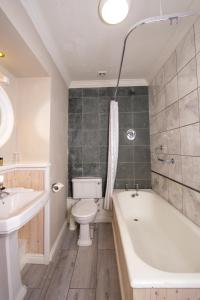 een badkamer met een bad, een toilet en een wastafel bij Foyles Hotel in Clifden