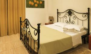 a bedroom with a black and white bed with white sheets at Kallisti Apartments in Skiathos Town