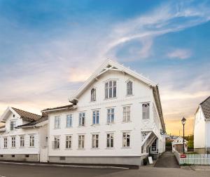 - un bâtiment blanc avec des fenêtres donnant sur une rue dans l'établissement Lillesand Hotel Norge, à Lillesand