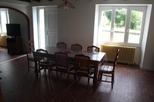 uma sala de jantar com mesa e cadeiras em Gîte du courtil aux fées em Saint-Laurent