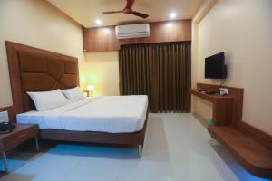 a hotel room with a bed and a television at Hotel Central Avenue in Sangli
