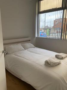 uma cama branca num quarto com uma janela em Nantwich House em Crewe