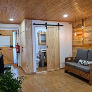 a living room with a couch and a sliding door at Casas Alba Odeceixe in Odeceixe