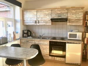 a kitchen with a table and a microwave at Minsener Warft in Wangerland