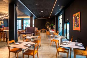 a dining room with tables and chairs in a restaurant at ONOMO Hotel Douala in Douala